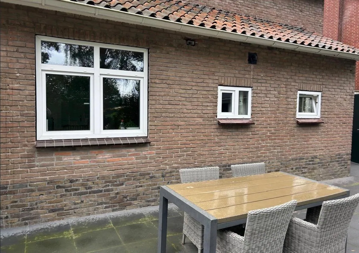 Drie witte ramen na montage in een gemetselde gevel
