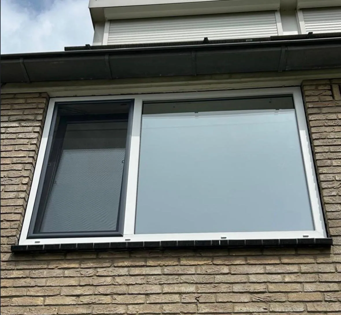 Raam met wit kozijn en antraciet draaideel na plaatsing